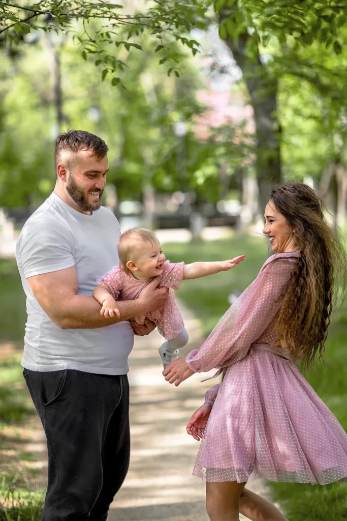 Веселая семейная фотосессия в парке: родители играют с маленькой дочкой